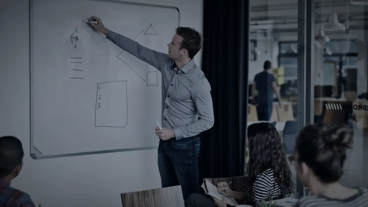 A project team working through a plan at a whiteboard
